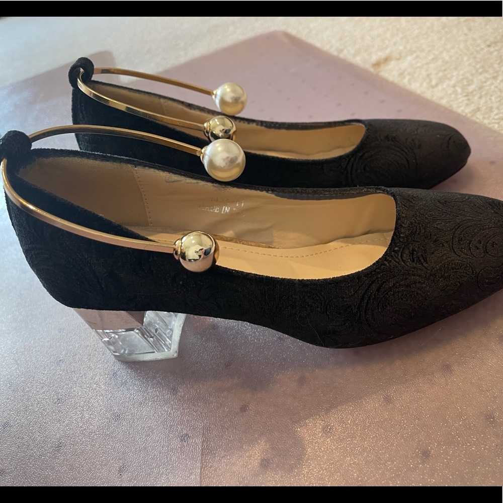 Trendy black shoes with glass heels.